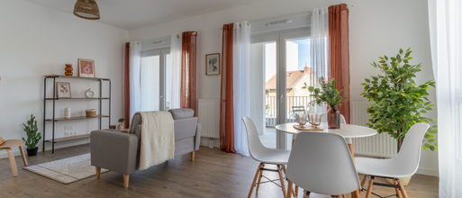 Piece de vie avec baies vitrées rideaux meublée canapé table chaises